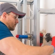 Plumber working on common plumbing issues scaled